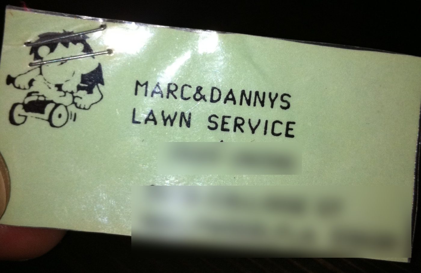 Business card for Marc and Danny's Lawn Service with a cartoon kid riding a mower